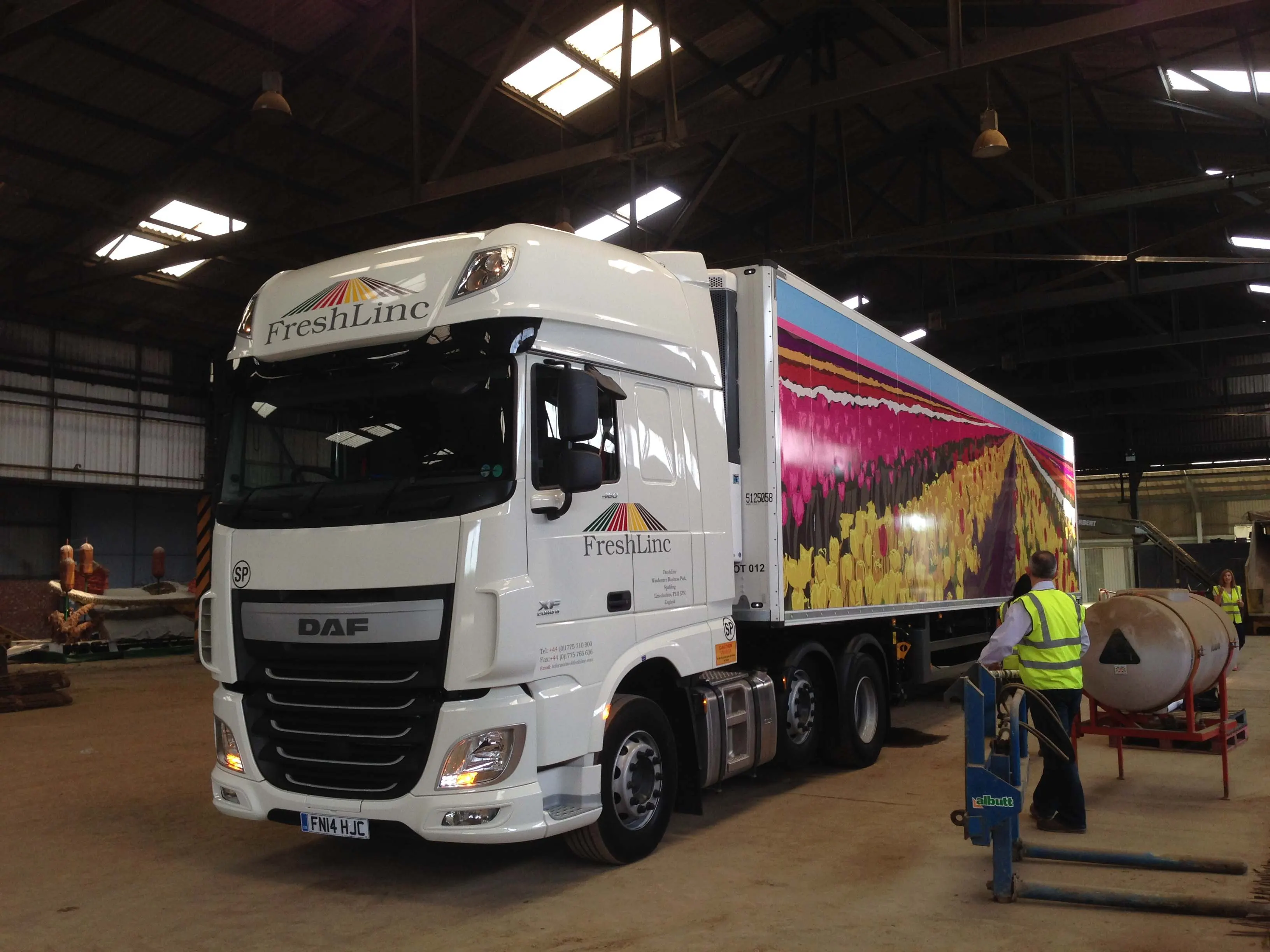 FreshLinc lorry with a large full-colour vehicle graphic being fitted in a workshop